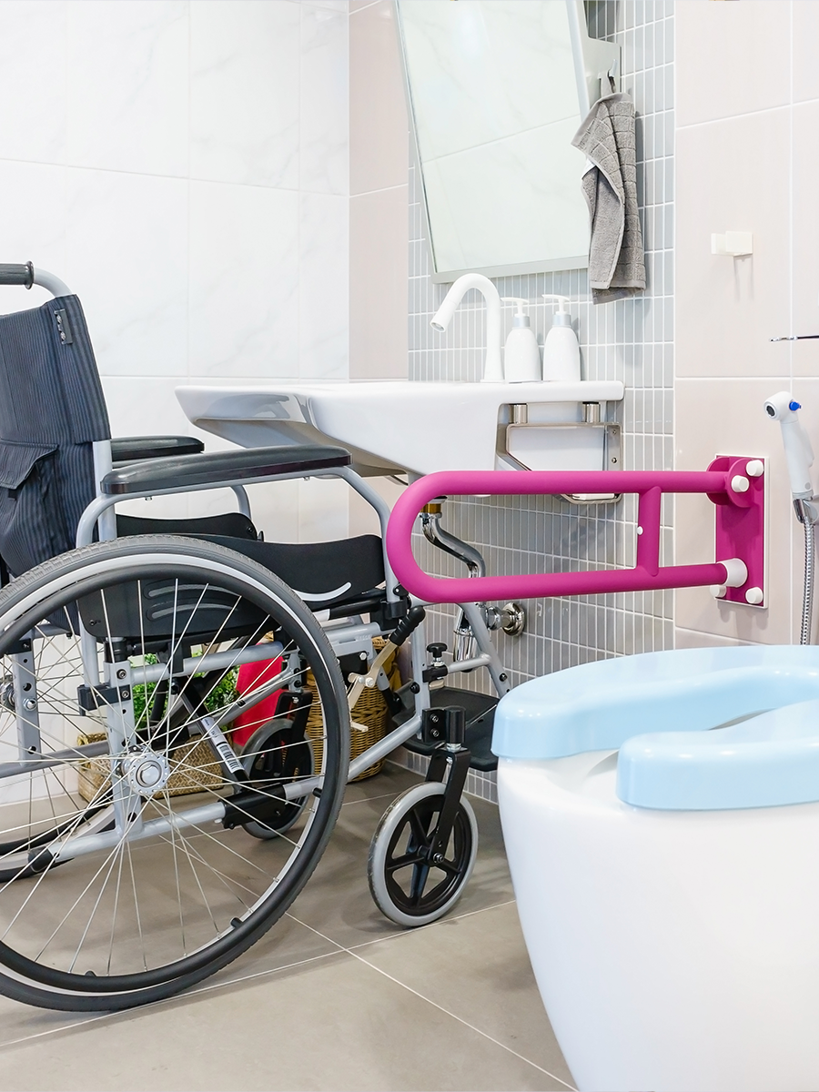 Accessible bathroom with wheelchair, support rail and adapted basin